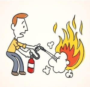 A man is using a fire extinguisher to put out the fire