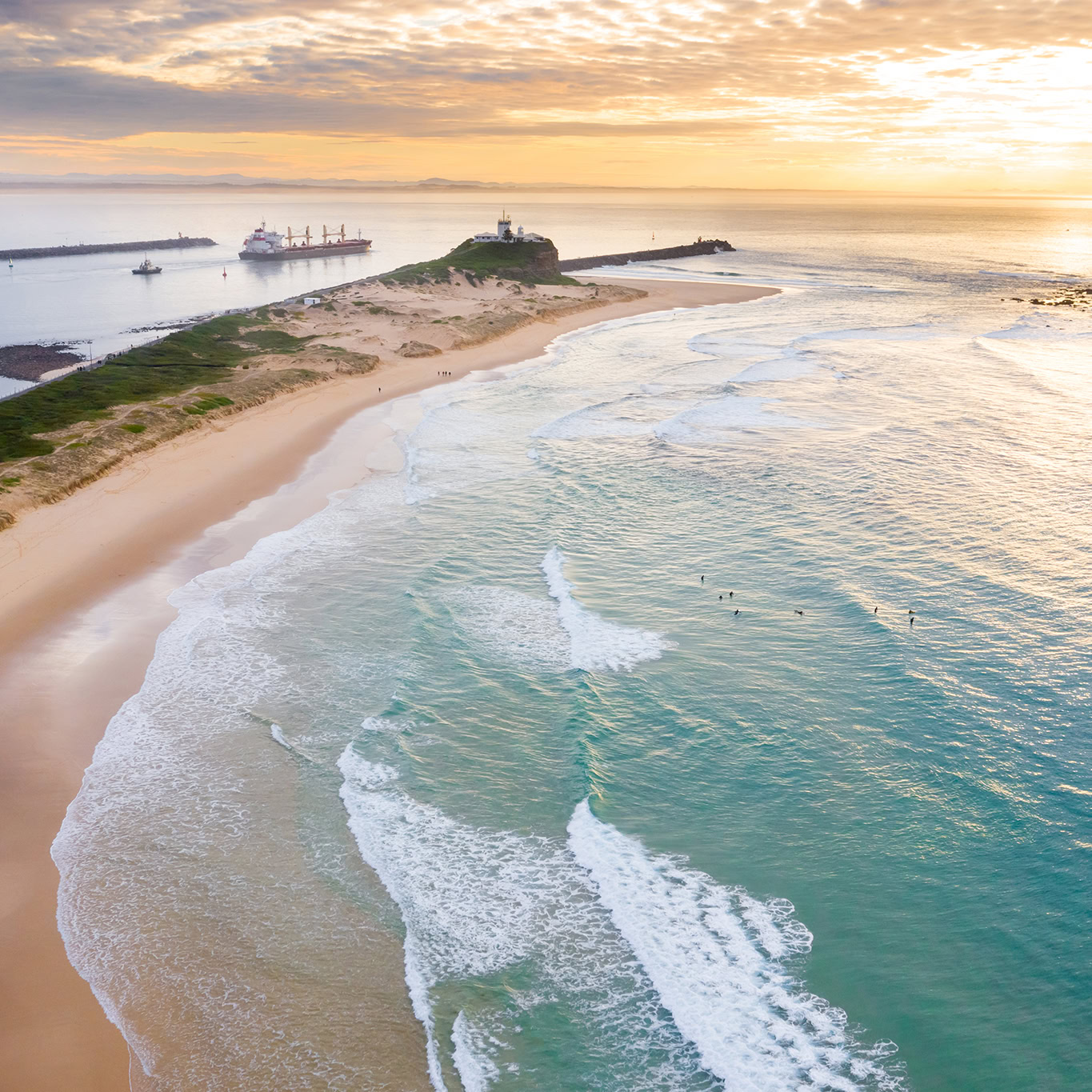 Aerial view of a seashore, showing the meeting point of the ocean waves and the sandy beach.