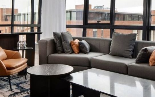 open plan living room, windows looking out to buildings, close up off sofa and coffee table