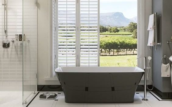 bathroom, including bathtub and shower, with open doors in the background