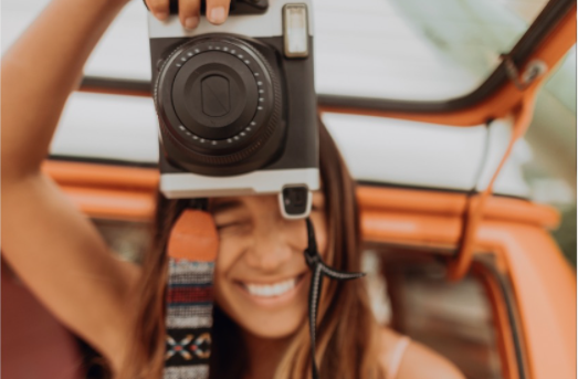 close up of a lady taking a photo with a professional camera in her hands