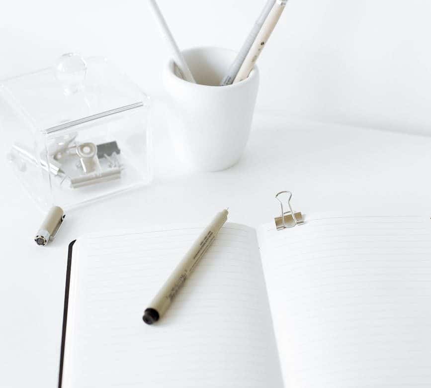 white notepad with pen on top of it