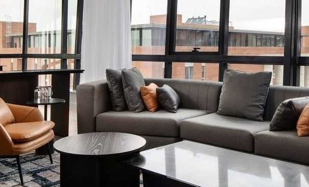 open plan living room, windows looking out to buildings, close up off sofa and coffee table