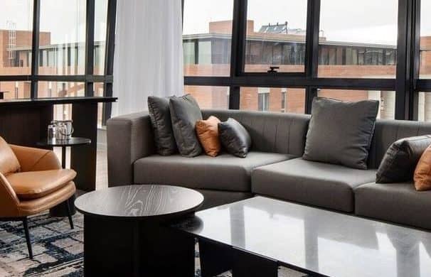 open plan living room, windows looking out to buildings, close up off sofa and coffee table