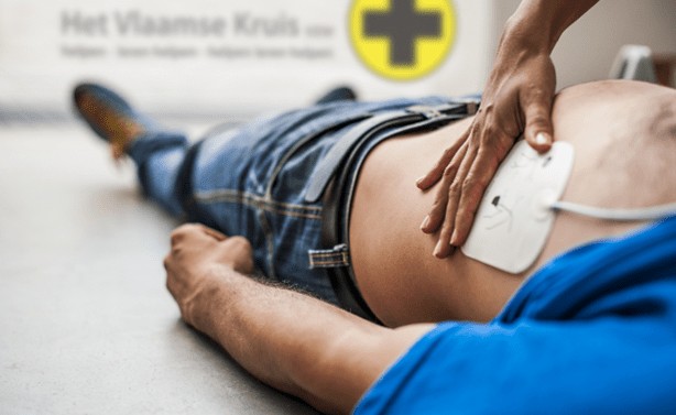 someone laying on floor, with a press pad on his side with a hand on the top of it