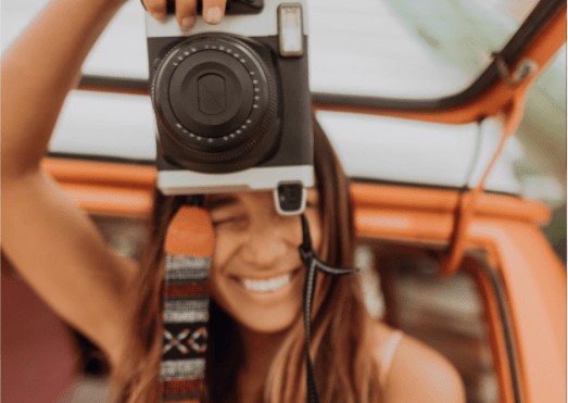 close up of a lady taking a photo with a professional camera in her hands