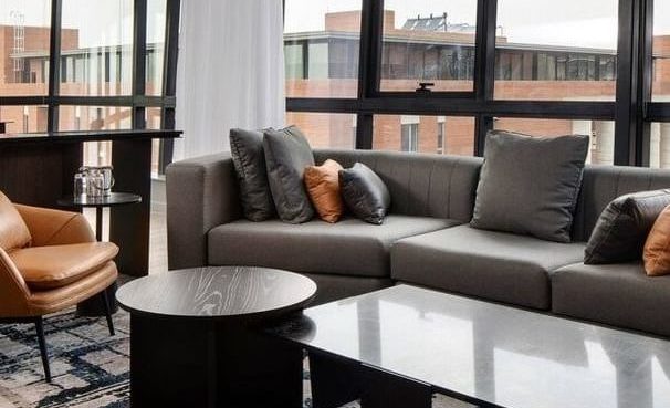 open plan living room, windows looking out to buildings, close up off sofa and coffee table