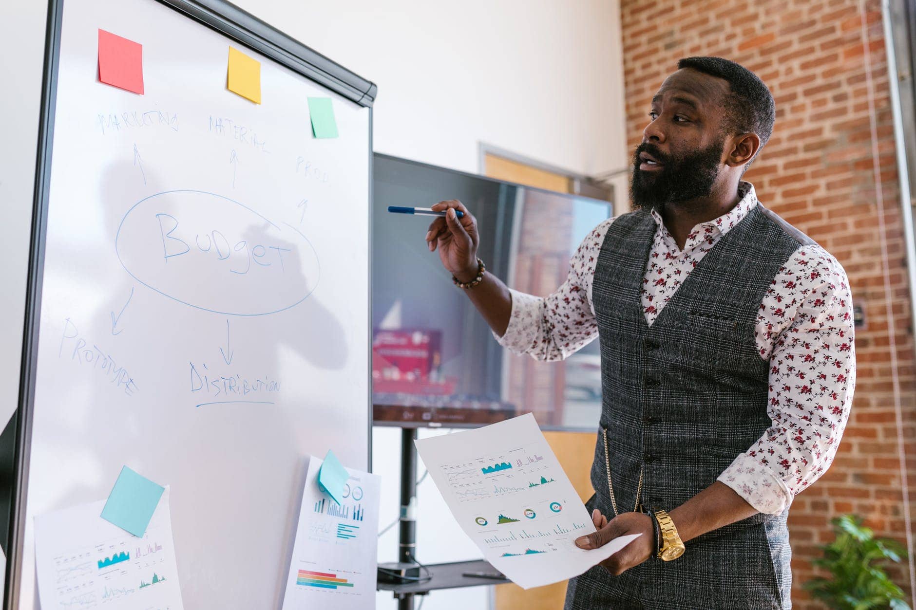 man standing in front of a whiteboard with a pen in his hand working something out to write on the board