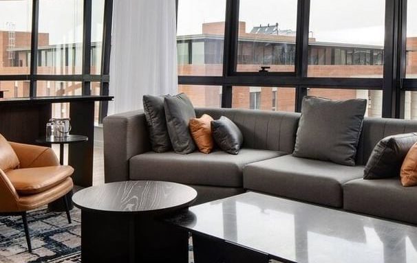 open plan living room, windows looking out to buildings, close up off sofa and coffee table