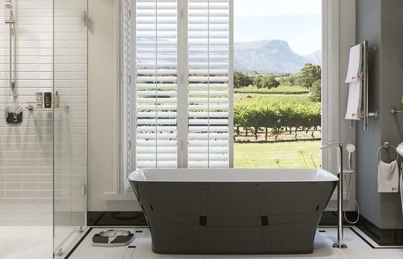 bathroom, including bathtub and shower, with open doors in the background