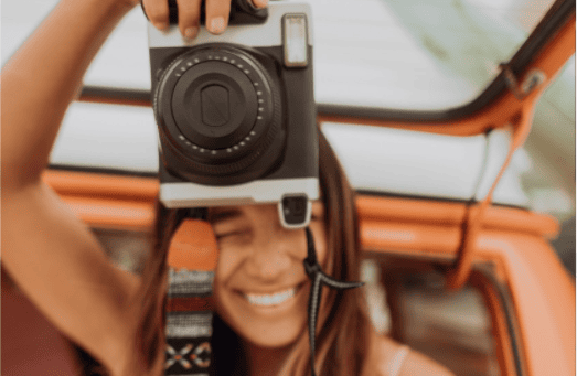 close up of a lady taking a photo with a professional camera in her hands