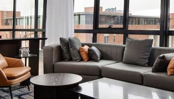 open plan living room, windows looking out to buildings, close up off sofa and coffee table