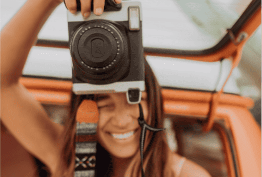 close up of a lady taking a photo with a professional camera in her hands