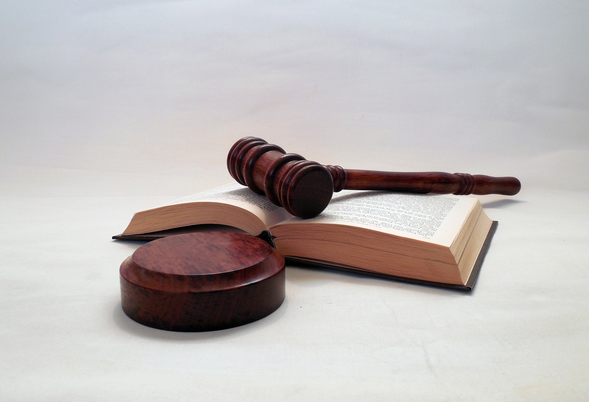 A judge's gavel and block with the gavel resting on an open book.