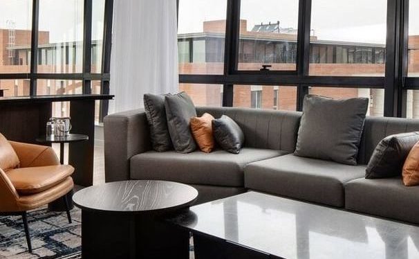 open plan living room, windows looking out to buildings, close up off sofa and coffee table