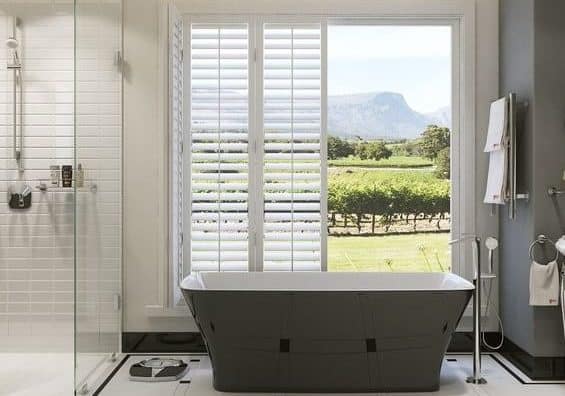 bathroom, including bathtub and shower, with open doors in the background