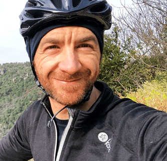 A portrait photo of a man wearing a bicycle helmet.