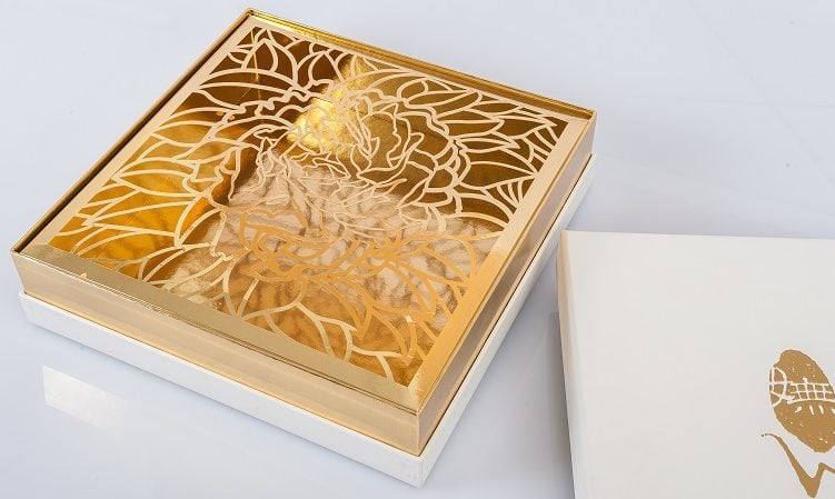 金盒位于包装顶部，带有花卉图案